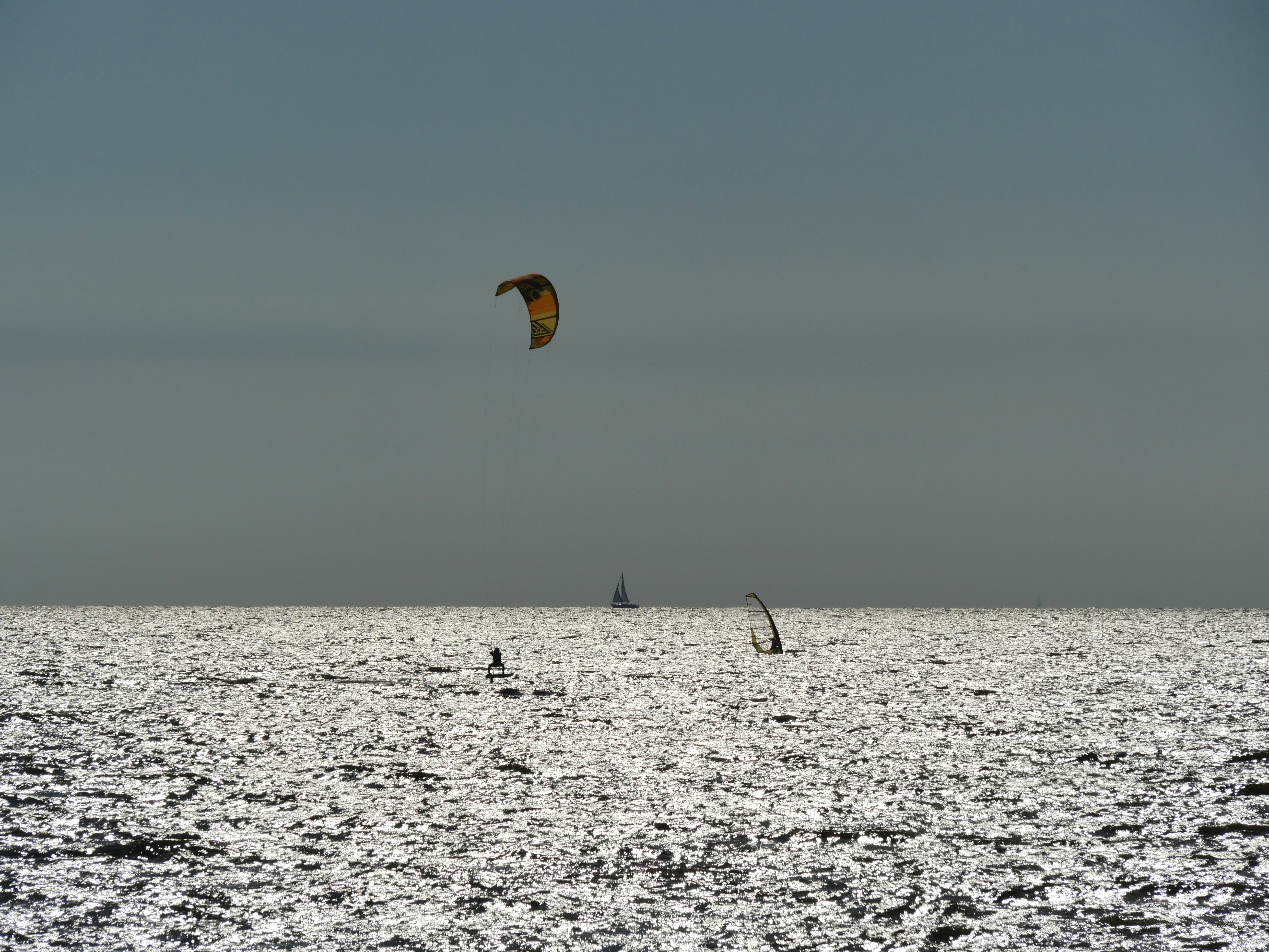 yellow and black kite surfing on sea during daytime